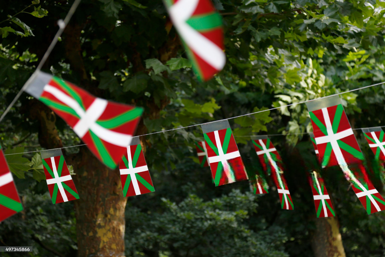 plaza en Beasain, con elementos tradicionales vascos como fondo, reflejando la importancia del euskera en la vida comunitaria